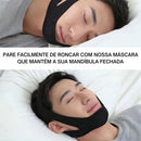 Pessoa deitada usando faixa preta sob o queixo e ao redor da cabeça